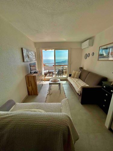 un salon avec un canapé et une table dans l'établissement 4 pièces vue mer - Mas de la mer, à Théoule-sur-Mer