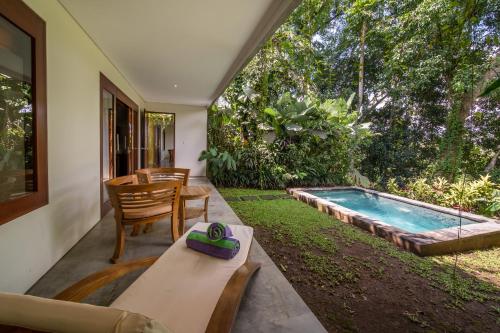 a backyard with a pool and a table and chairs at The Hidden Paradise Ubud - CHSE Certified in Ubud