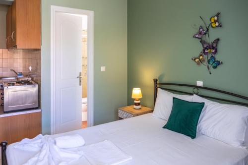 a bedroom with a white bed with a green pillow at Vista Verde Studios & Apartments in Svoronata