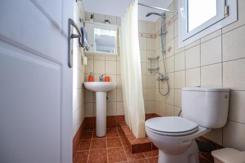 a bathroom with a toilet and a sink at Vista Verde Studios & Apartments in Svoronata