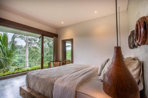 a bedroom with a large bed and a large window at The Hidden Paradise Ubud - CHSE Certified in Ubud