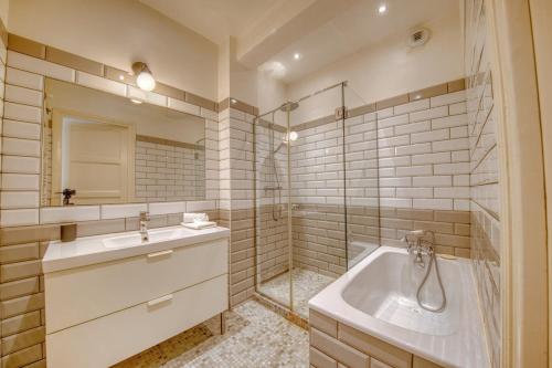ein Badezimmer mit Badewanne und Waschbecken in der Unterkunft Excellence - 4 bedrooms in Reims