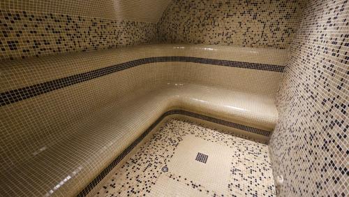 a bath tub in a tiled bathroom with a shower at Апартамент Edelweiss in Beli Iskar