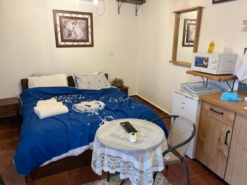 a bedroom with a bed with a table and a mirror at לומינוס הגפן in Ḥurfeish