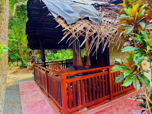 a porch of a hut with a thatched roof at Turtle Watch Cabana in Tangalle