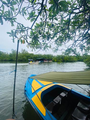 a blue and yellow boat sitting on the water at Silver Lake Villa & Boat Safari in Balapitiya