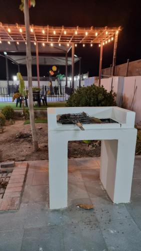 a white bench sitting in a park at night at بيوت الضيافة shmma house in Ḩaḑīb
