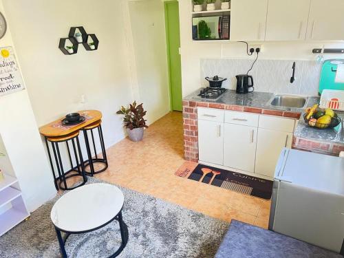 a kitchen with white cabinets and a table and a sink at Pequeno Cielo Staycation in Nairobi