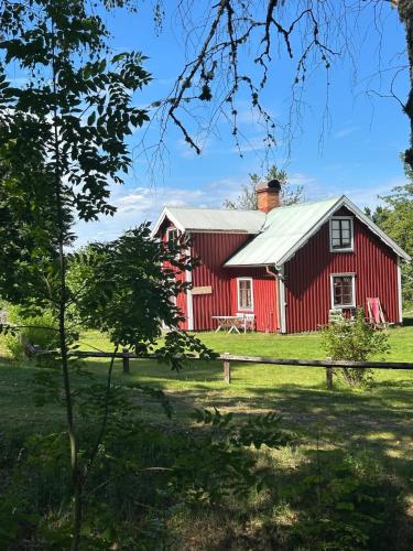 a red barn with a white roof at Skänninge Vimmerby in Vimmerby