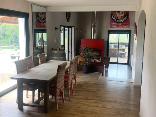 a dining room with a wooden table and chairs at Beautiful architectural villa 10 pool beds in Laure-Minervois