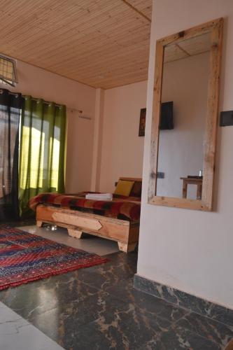 a room with a mirror and a bed in it at Namaha hotel and cottages in Kanatal
