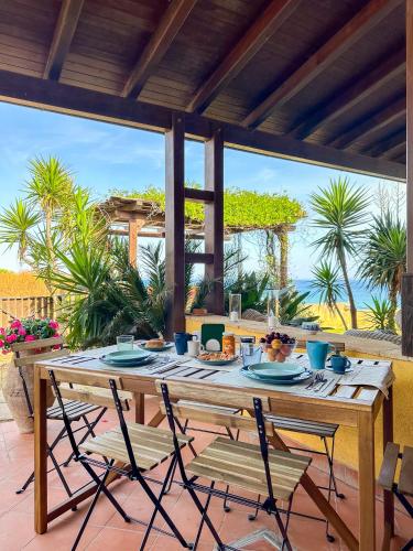 a wooden table with chairs on a patio at Casa di Bruca in Marinella di Selinunte