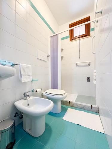 a white bathroom with a toilet and a sink at Casa di Bruca in Marinella di Selinunte