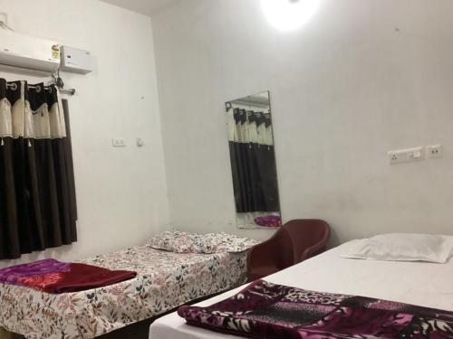 a room with two beds and a mirror at Shivay Guest house in Jasidih