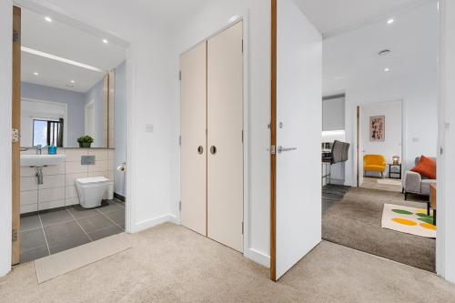 a hallway with a bathroom and a living room at Modern Luxurious Central Apartment in Manchester
