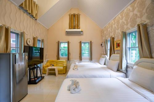 a living room with three beds and a tv at Puprai Tarnnarm Resort in Thong Pha Phum
