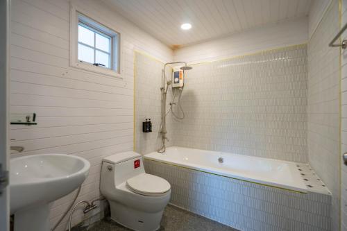 a bathroom with a toilet and a tub and a sink at Puprai Tarnnarm Resort in Thong Pha Phum