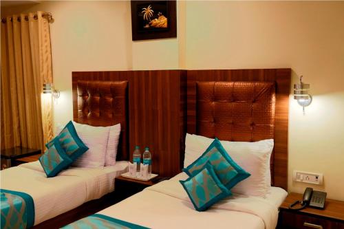 a hotel room with two beds with blue and white pillows at RTS HOTEL & Spa in New Delhi