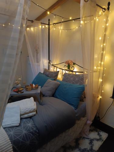 a bedroom with a bed with lights on it at Jolie maison de village in Capendu