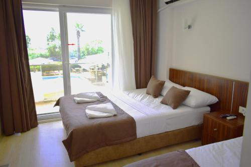 a bedroom with a bed and a large window at Mulka Hotel in Ayvalık