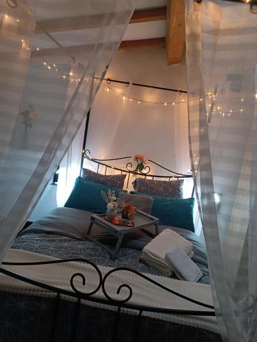 a bedroom with a canopy bed with a table at Jolie maison de village in Capendu