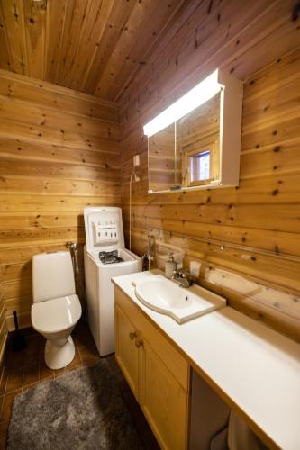 a bathroom with a toilet and a sink and a stove at Pytkynkulma in Syöte