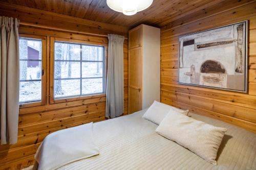 une chambre avec un lit dans un mur en bois dans l'établissement Pytkynkulma, à Syöte