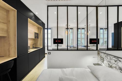 - une chambre avec un lit blanc et des murs noirs dans l'établissement F2 rue St honoré D ,Hypercentre à 2 minutes du Palais des congrès, à Cannes