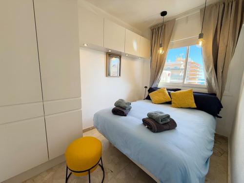 een slaapkamer met een groot bed en een gele stoel bij Sunny & modern beach apartment in Fuengirola