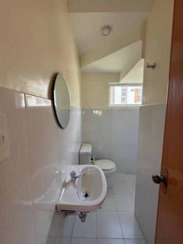 a bathroom with a sink and a toilet at Velmiro Greens dauis Panglao - 3 bedroom apartment unit P1112 in Dauis