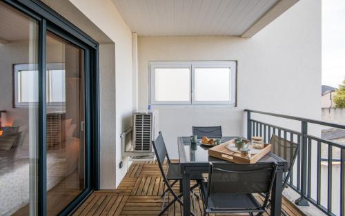 un balcon avec une table et des chaises dessus dans l'établissement Le Paris - Elégant, Parking privé et Terrasse, à Rodez