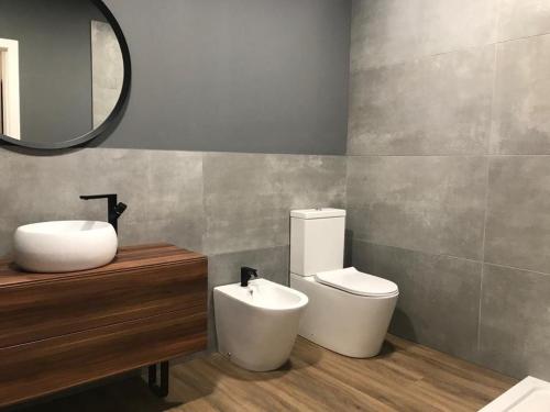 a bathroom with a sink and a toilet and a mirror at Loft Coruña Mar in A Coruña