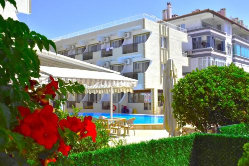 a hotel with a swimming pool in front of a building at Mulka Hotel in Ayvalık