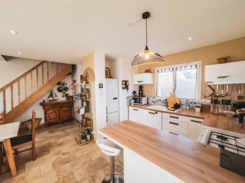 une cuisine avec des armoires blanches et un comptoir en bois dans l'établissement La Carpe Diem, à Cervione