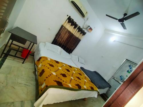a bedroom with a bed with a blanket on it at Shivay Guest house in Jasidih