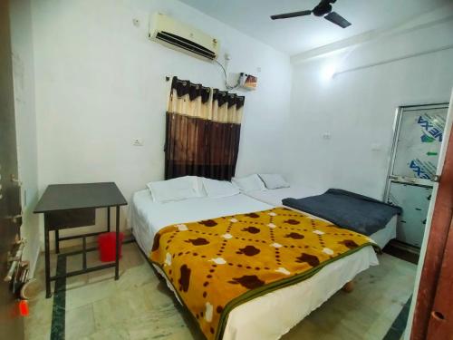 a bedroom with a bed and a table in it at Shivay Guest house in Jasidih
