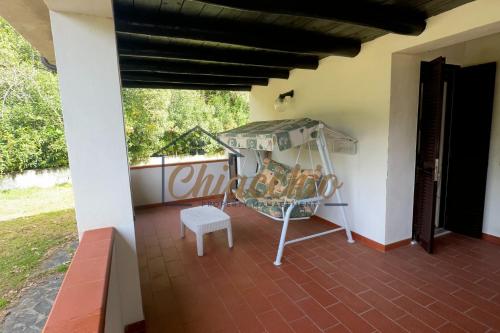 a porch of a house with a table and a stool at Villetta Gentili a due passi dal Mare - Patio e Parcheggio in Policastro Bussentino