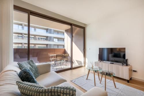 a living room with a couch and a tv at Splendid Apartment with a Terrace in Vila Nova de Gaia