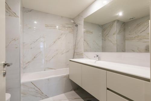 a white bathroom with a tub and a sink at Splendid Apartment with a Terrace in Vila Nova de Gaia