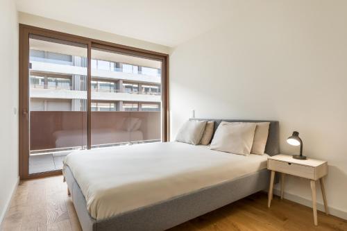 a bedroom with a bed and a large window at Splendid Apartment with a Terrace in Vila Nova de Gaia
