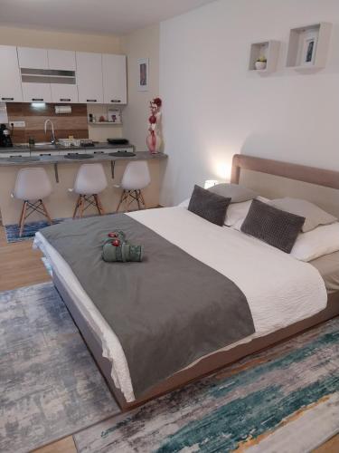 a bedroom with a large bed and a kitchen at Repi-Tár apartman in Szolnok