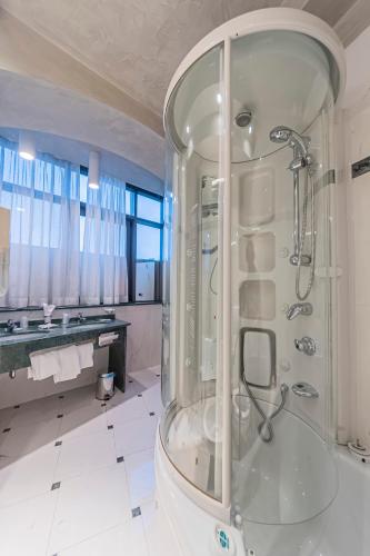 a large bathroom with a shower with a glass enclosure at Dado Hotel International in Parma