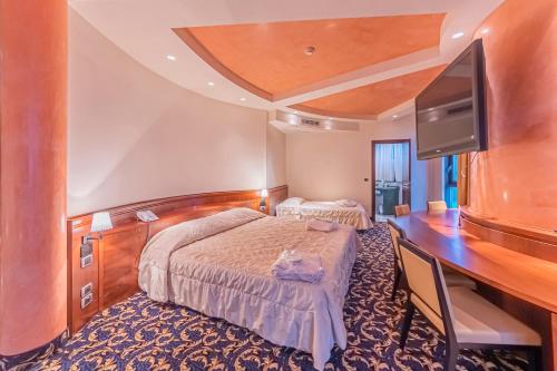 a hotel room with a bed and a flat screen tv at Dado Hotel International in Parma