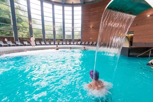 une personne dans une piscine avec une fontaine dans l'établissement CENTRAL & STANDING GERMES, traversant avec parking - Lits 180 King Size et 160 Queen Size - Linge de lit et de toilette inclus, à Luchon