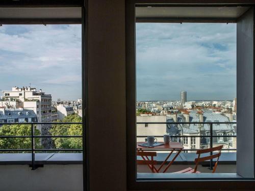 a room with a table and a view of a city at Mercure Paris 17 Batignolles in Paris