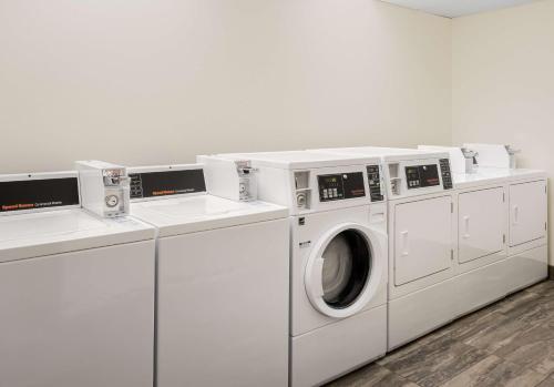 a white laundry room with three washing machines at Hyatt Place Santa Cruz in Santa Cruz