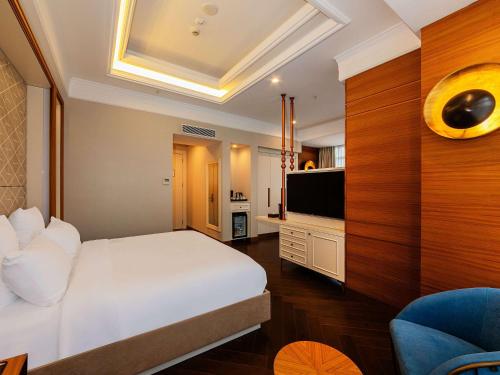 a bedroom with a white bed and a television at Mercure Istanbul Sirkeci in Istanbul