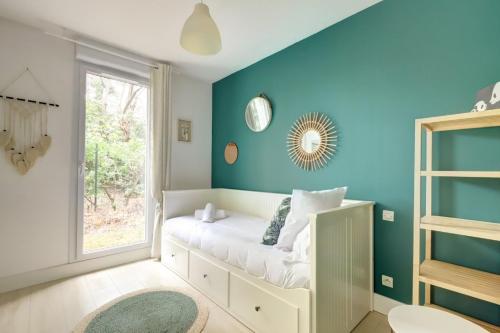 - une chambre avec des murs bleus et un lit avec une fenêtre dans l'établissement Le Bon Voyage ~ Terrasse ~ Parking ~ Basso Cambo, à Toulouse