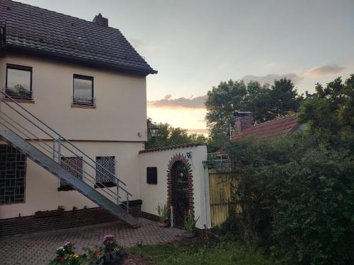a white house with a staircase and a fence at Ferienhaus Stani in Eschwege