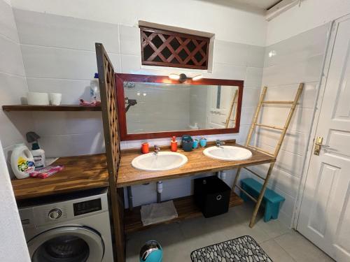 a bathroom with two sinks and a washing machine at La villa créole de Vaughenlieu in Lamentin